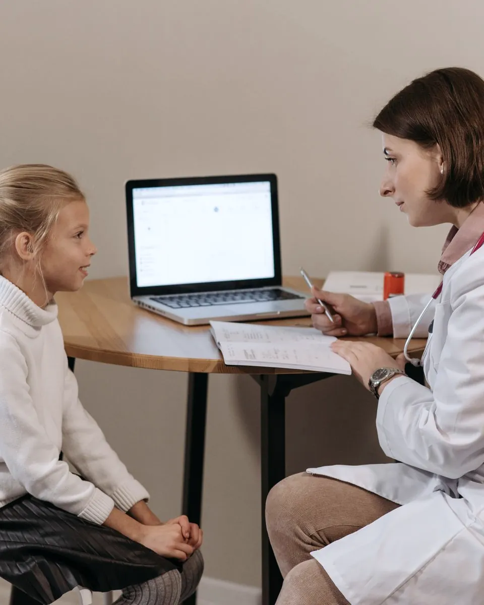 A doctor talking with a mother and her daughter